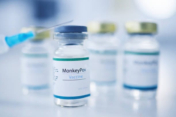 Monkeypox vaccine, backgrounds and injection vial for medicine, safety and healthcare risk. Closeup, liquid bottle and virus vaccination of medical drugs, wellness and pharmaceutical science research