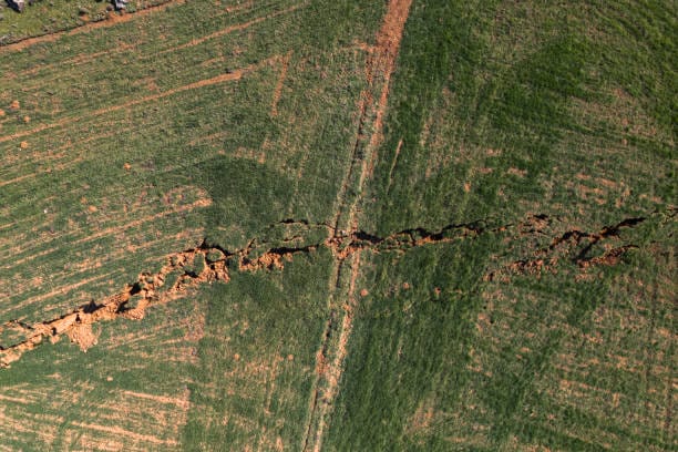 The image of the broken fault line stretching for kilometers of a very large earthquake in the agricultural area. Faults of the earth crust, consequence of the earth. Fault line break.