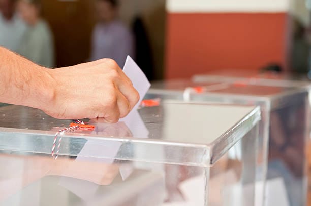 Unrecognizable person putting paper in sealed  transparent box, voting for elections, shallow doff