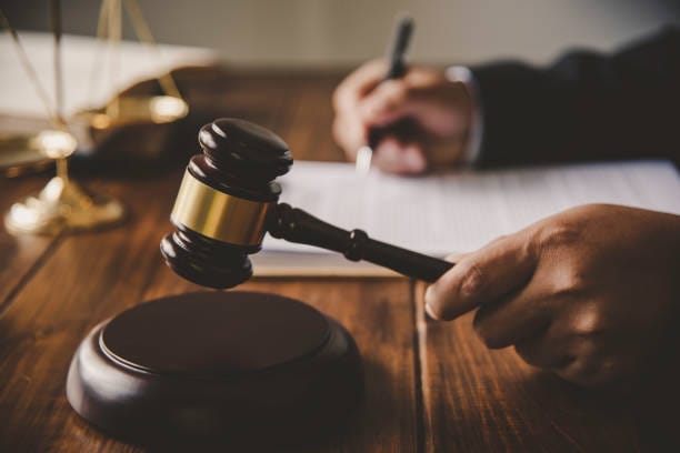 Cropped Hand Of Judge Holding Gavel On Desk